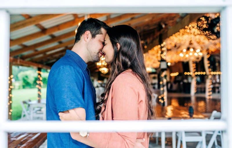 Couple kissing as they hug close together at the Wishing well barn in Plant City, FL